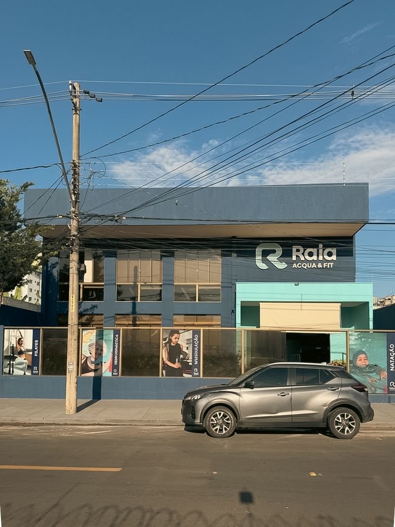 Fachada azul da Raia Acqua & Fit na Rua R-6, com estacionamento na porta